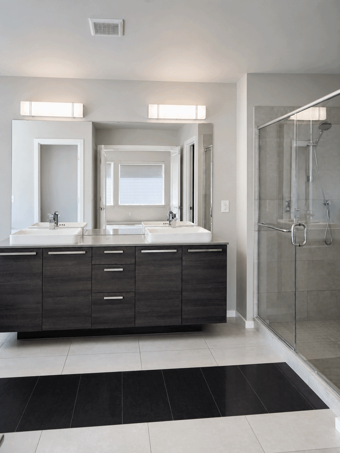 Bright double vanity and glass shower after regular cleaning