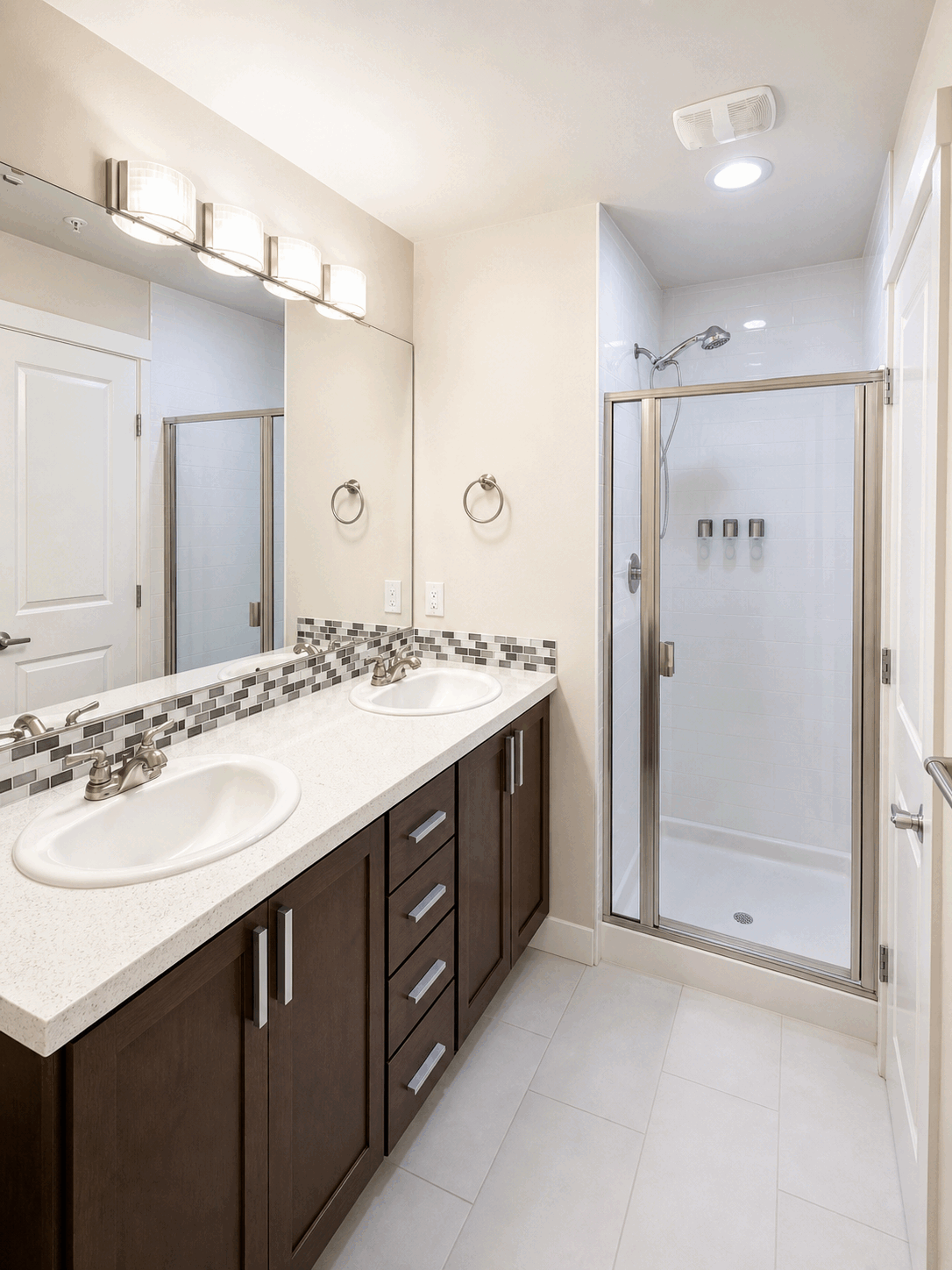 Guest-ready bathroom with bright double vanity and clean shower