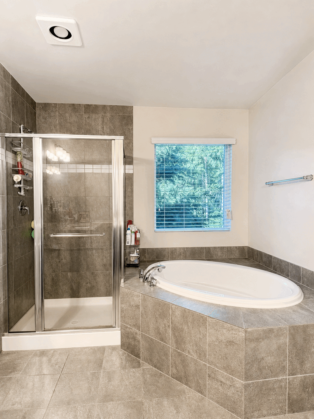 Clean bathroom with shining glass shower and soaking tub