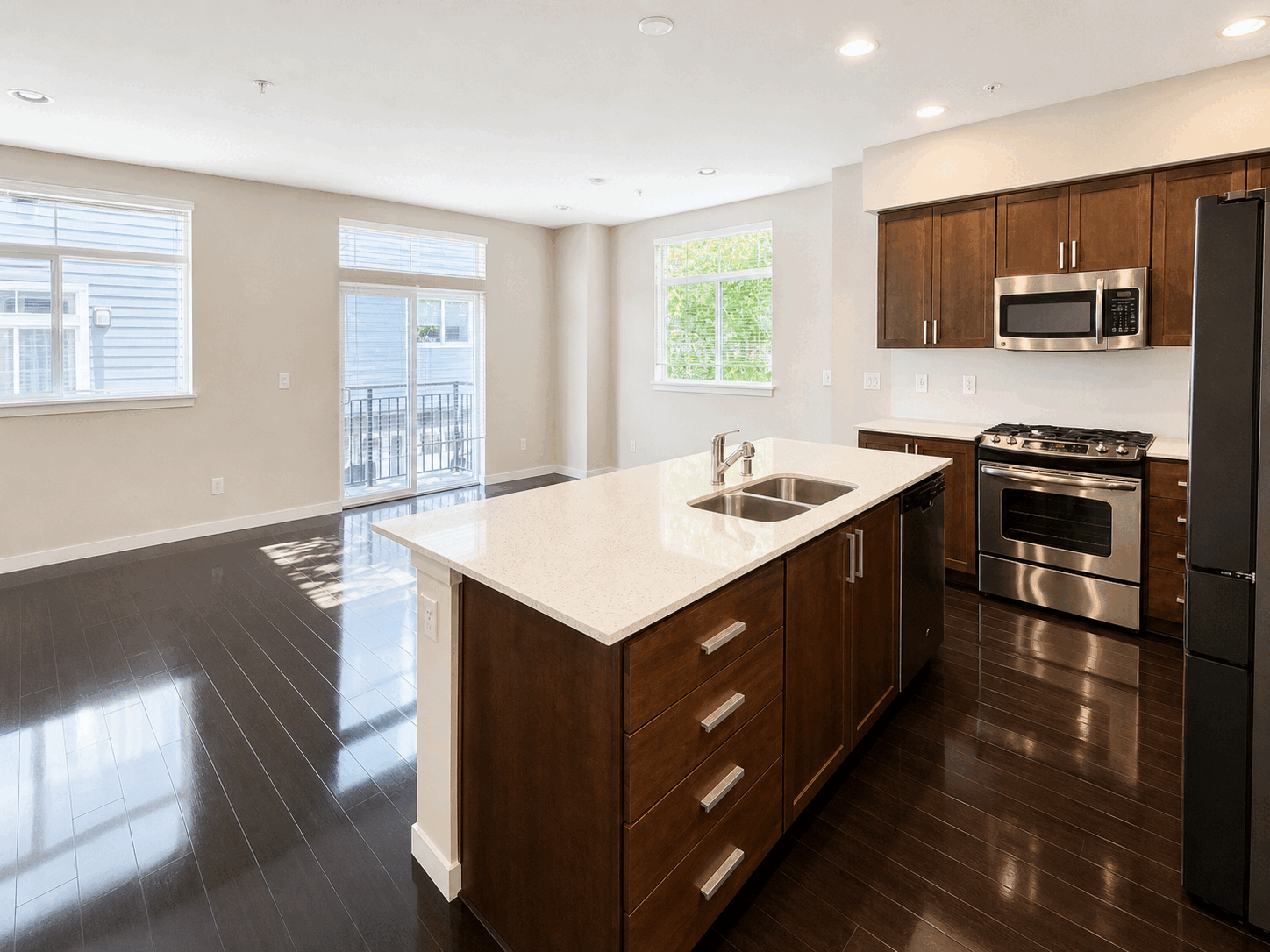 Wide clean kitchen with bright counters and glossy floors