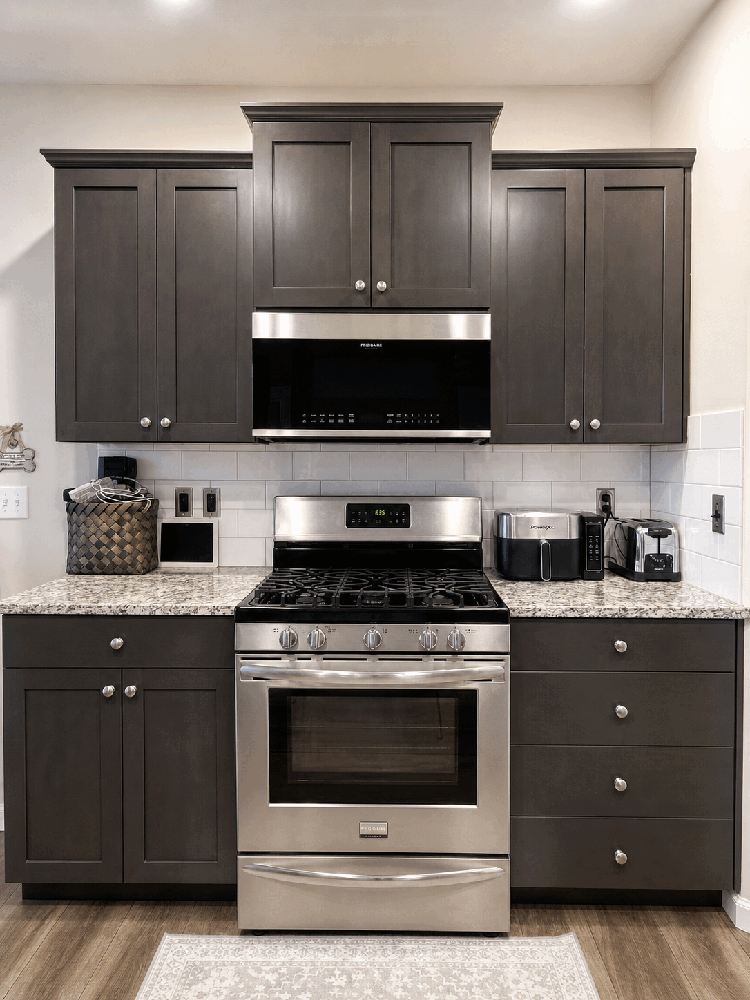 Clean range, microwave, counters, and dark kitchen cabinets